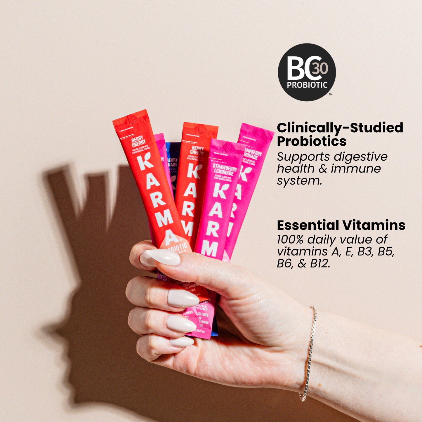 Hand holding Karma probiotic packets with B30 Probiotics branding and product information.